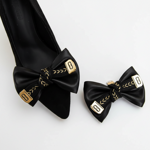 A pair of black pointed-toe high heels with matching bow headbands, both decorated with gold braided trim and gold-tone hardware featuring a stylized '8' emblem, displayed on a beige background with white blocks.