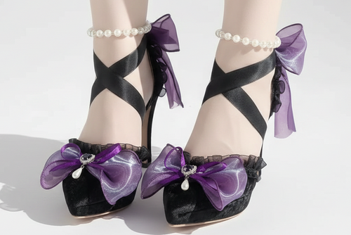 Black high-heeled shoes with purple ribbons and decorative elements on a white background.