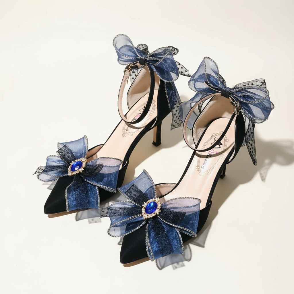 A pair of high-heeled Lolita-style shoes in dark blue velvet and navy blue mesh, decorated with large bows, blue rhinestone accents, and ankle straps, displayed on a reflective surface.